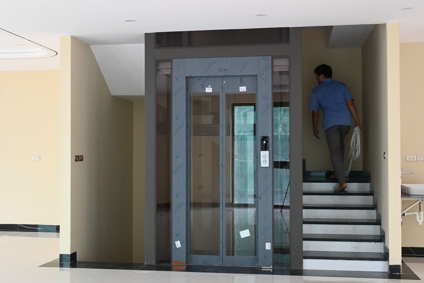 Thang máy khung xám đặt cạnh lõi thang bộ